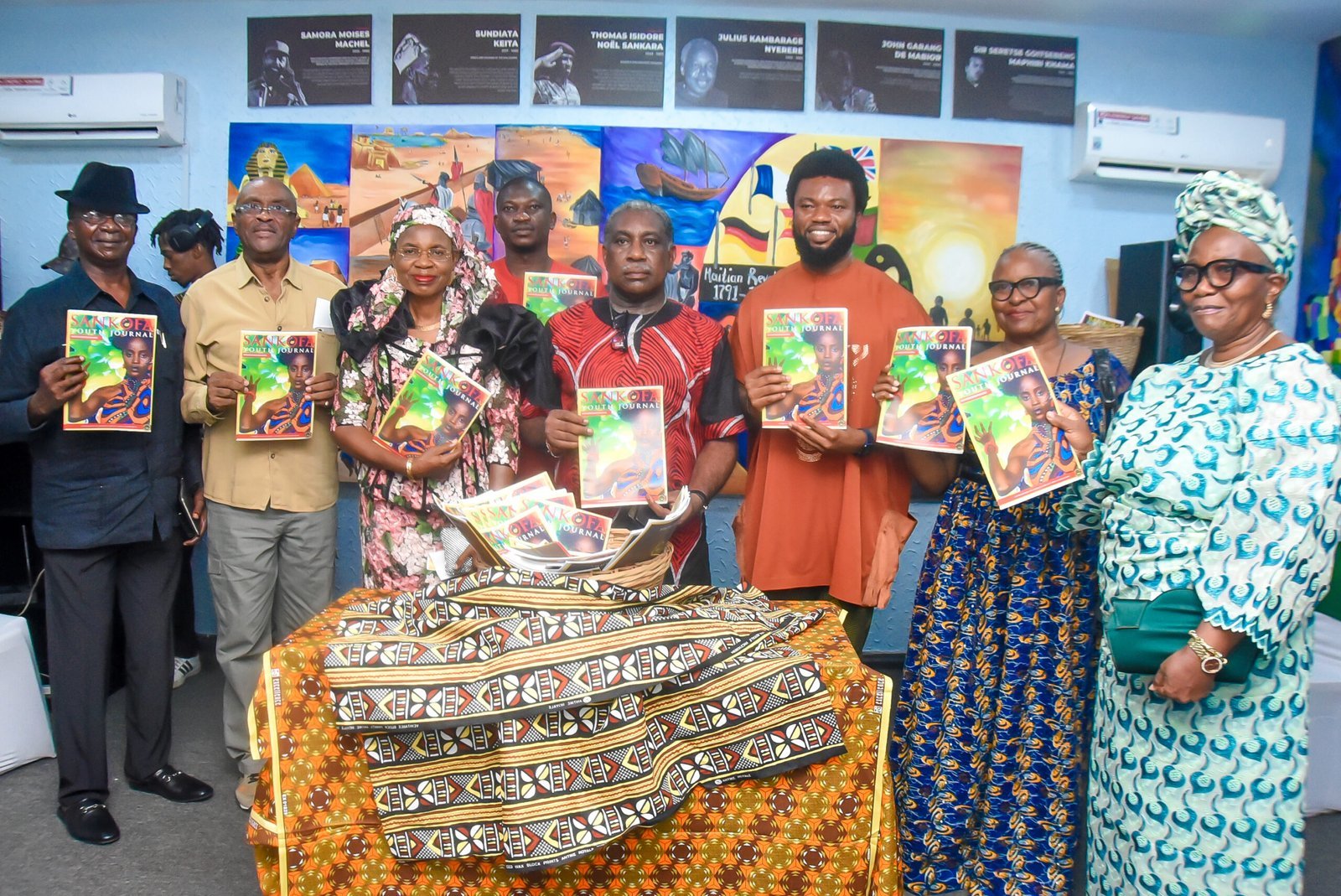 Des invités tenant des exemplaires du Sankofa Youth Journal autour d’une table